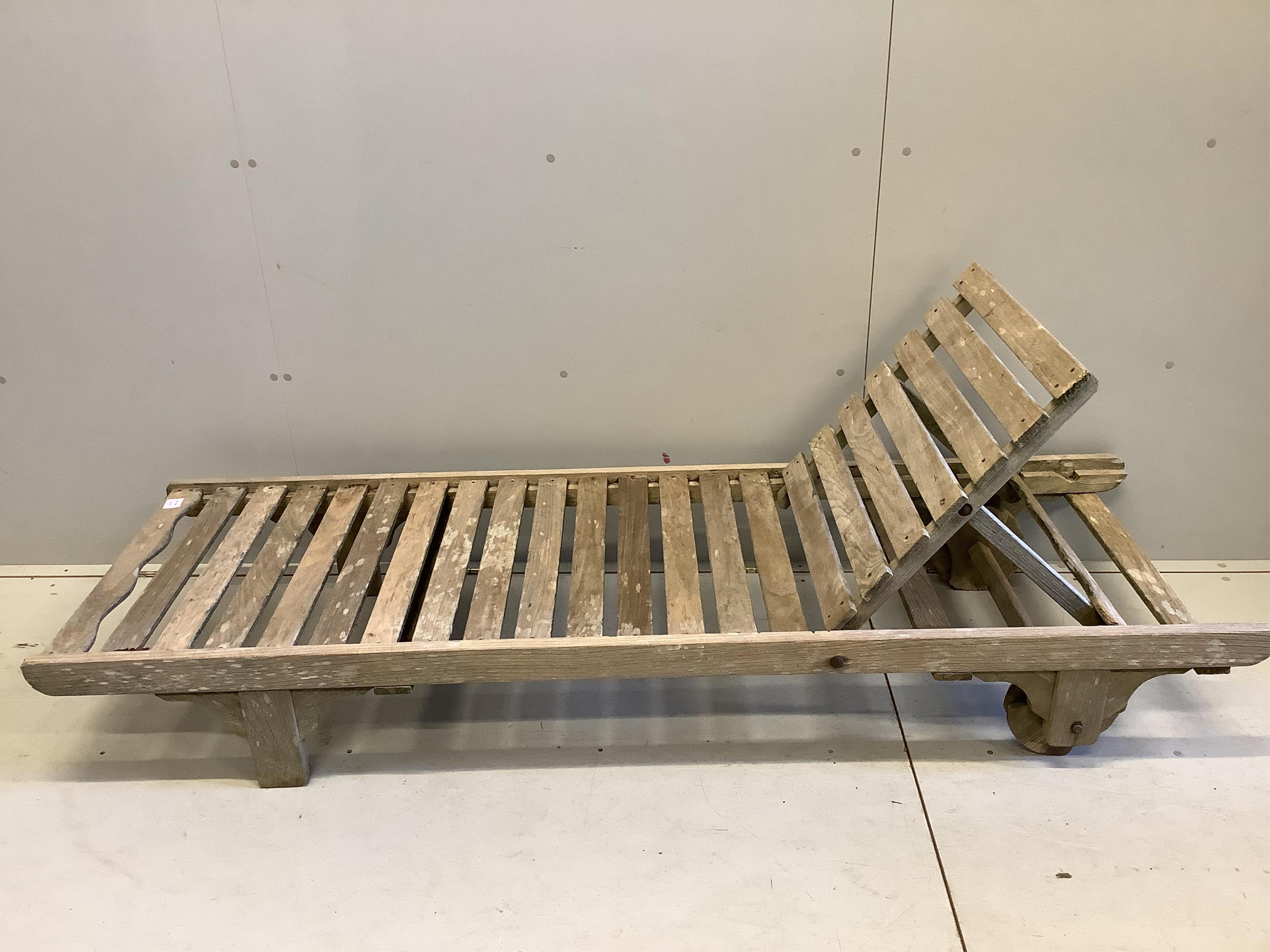 A weathered teak lounger, possibly Lister, width 64cm, length 195cm. Condition - poor